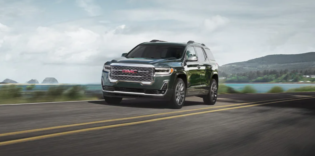 A gray 2023 GMC Acadia zooming on a road.