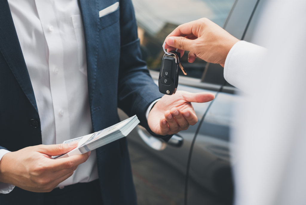 A car dealer handing keys to a customer.