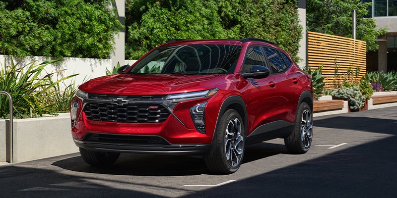 A red 2024 Chevy Trax parked in the driveway.