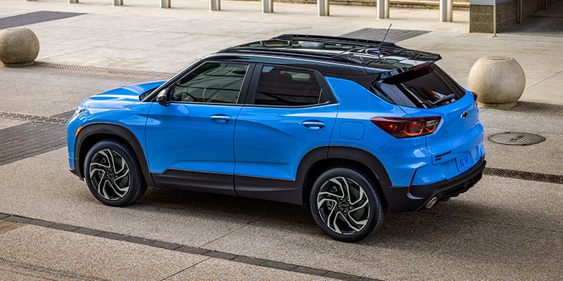 A vibrant blue 2024 Chevy Trailblazer, parked in a parking spot.