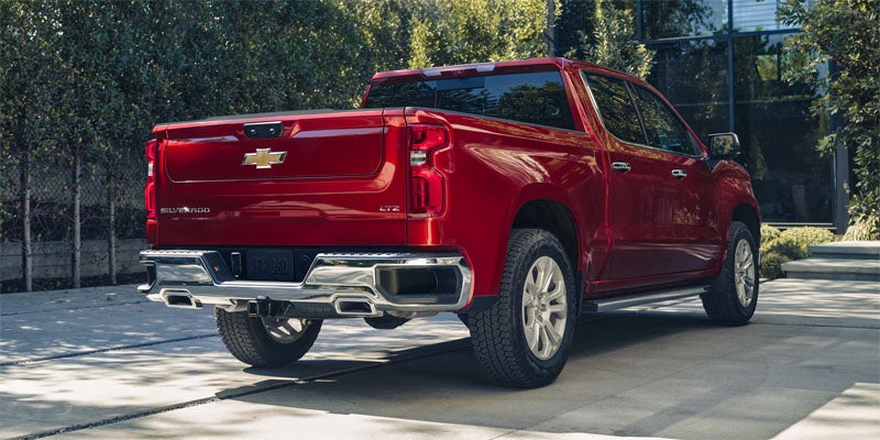 Red Chevrolet Silverado parked outside a modern building.